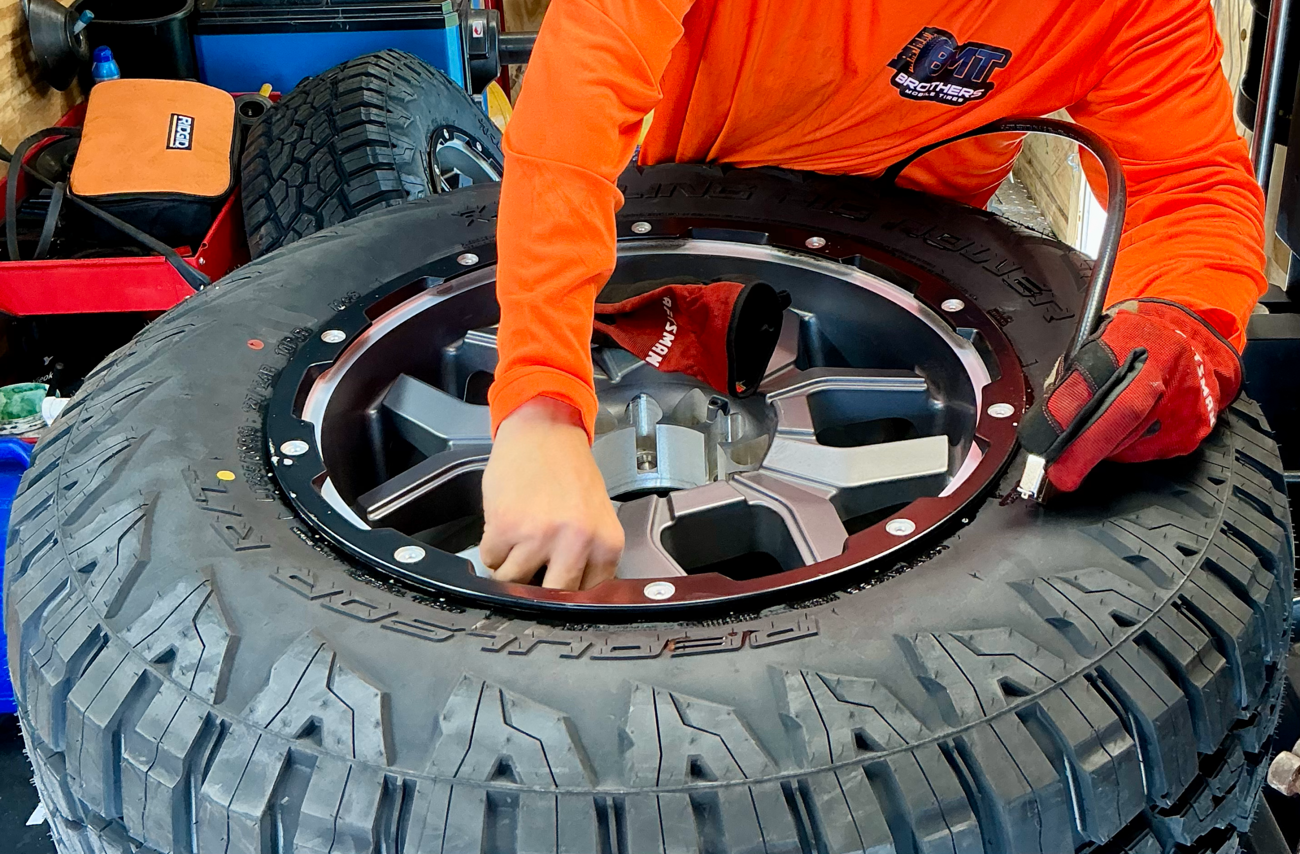 Technician mounting a tire onto a rim during mobile service